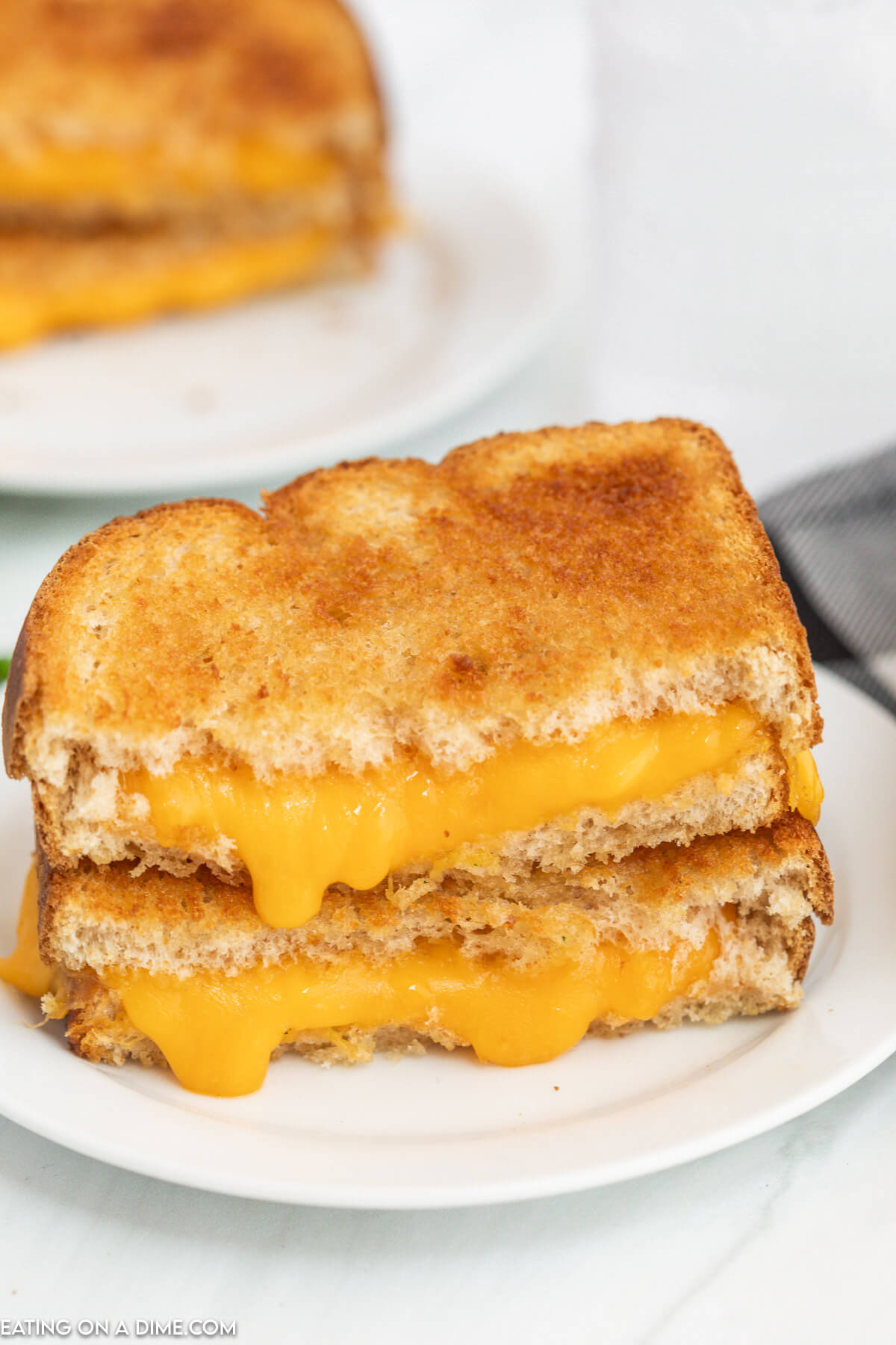 Grilled Cheese cut in half stacked on a plate