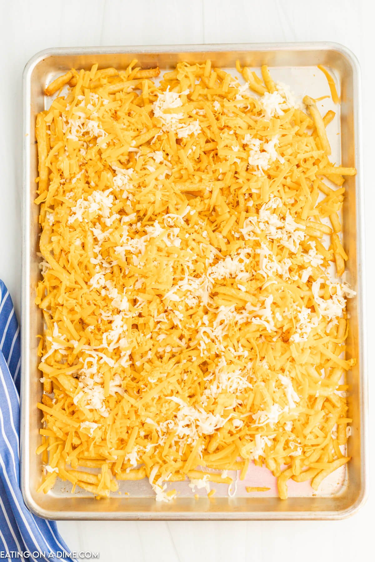 Topping fries with shredded cheese