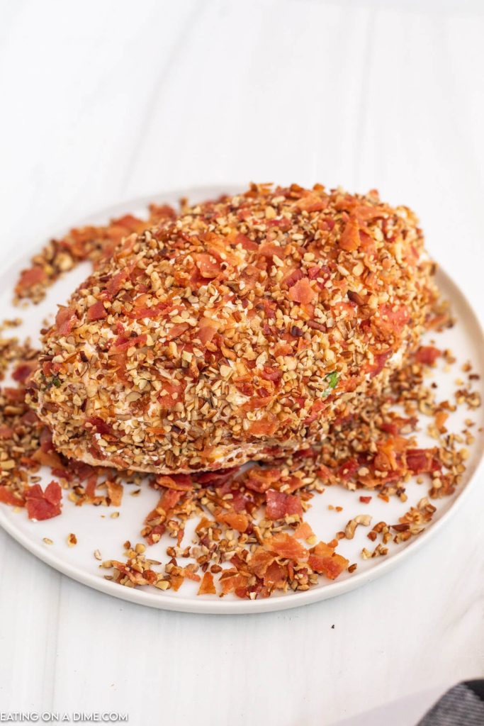 Rolling cheeseball in bacon and nuts