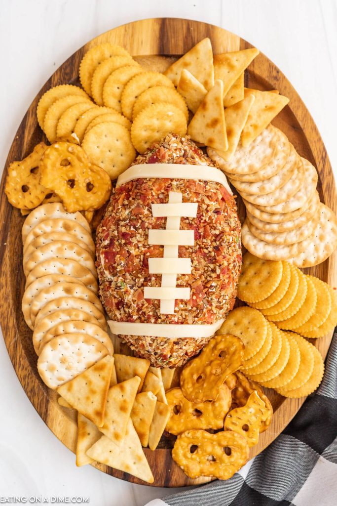 Close up image of Football Cheese Ball on a platter with crackers
