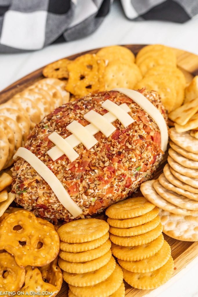 Close up image of Football Cheese Ball on a platter with crackers