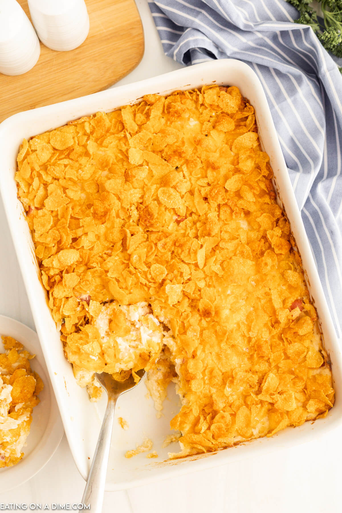Funeral potatoes in a baking dish with a spoon