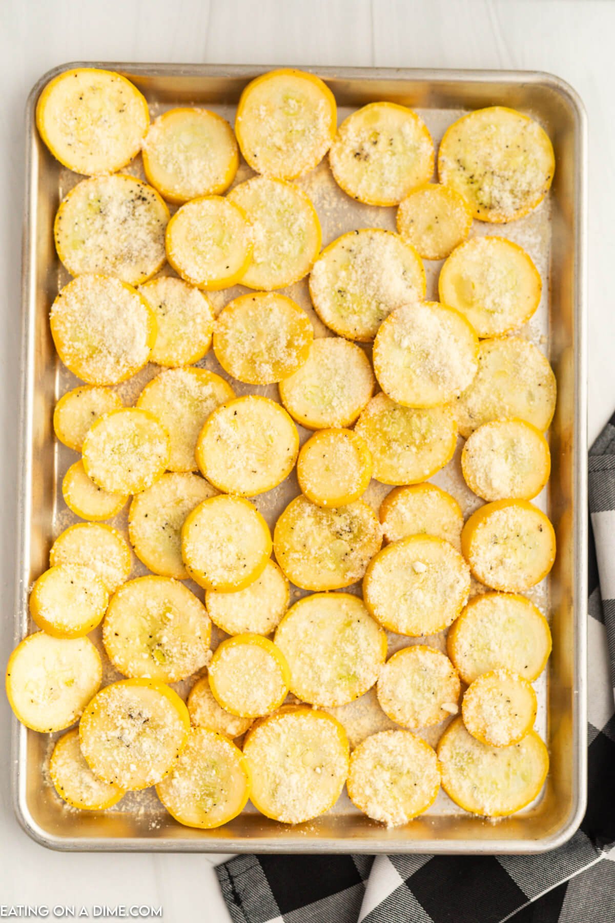 Slice yellow squash seasoned on a baking sheet