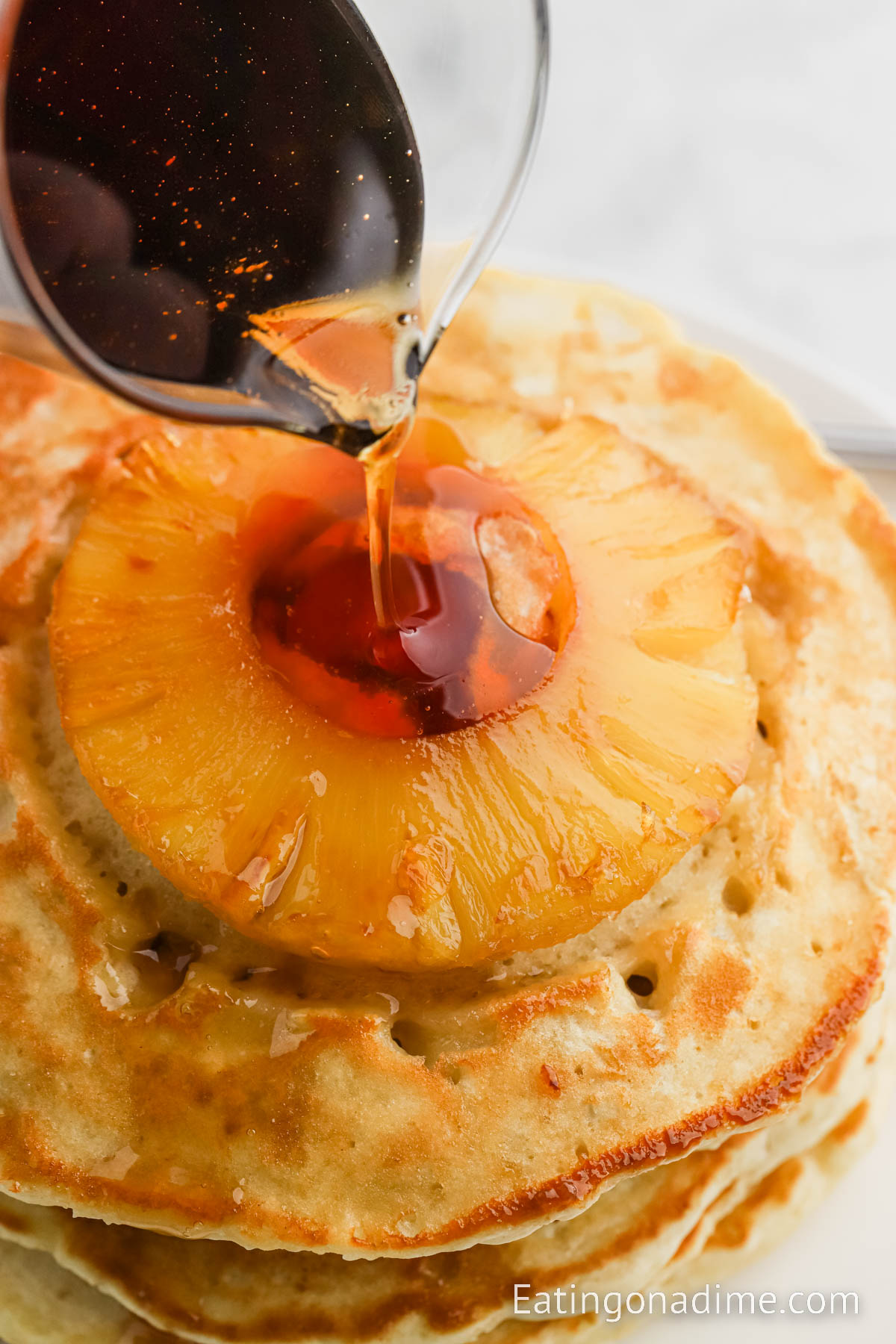 Pour syrup over pineapple upside down pancakes