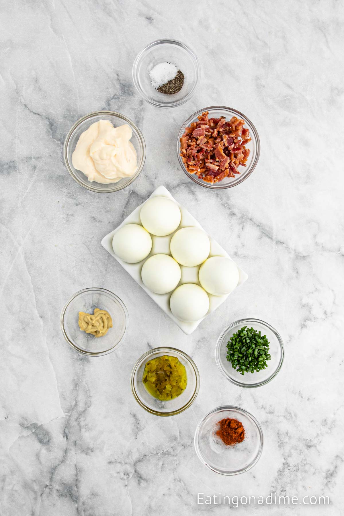 Hard boiled eggs, mayonnaise, mustard, pickle relish, salt and pepper, paprika, bacon, chives