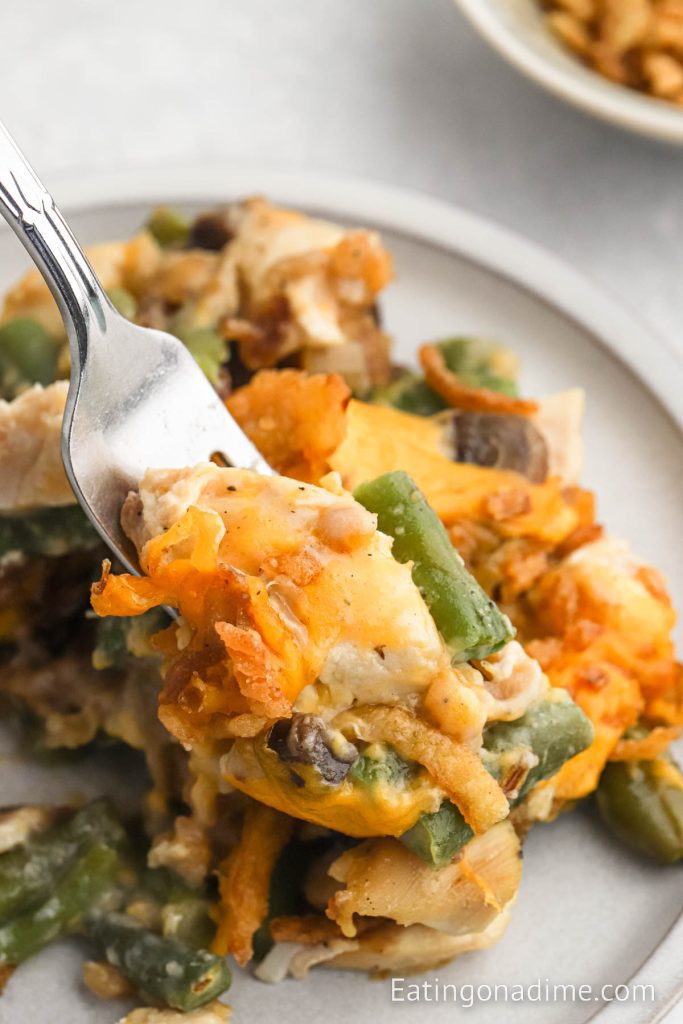 Chicken green bean casserole on a plate with a bite on a fork. 