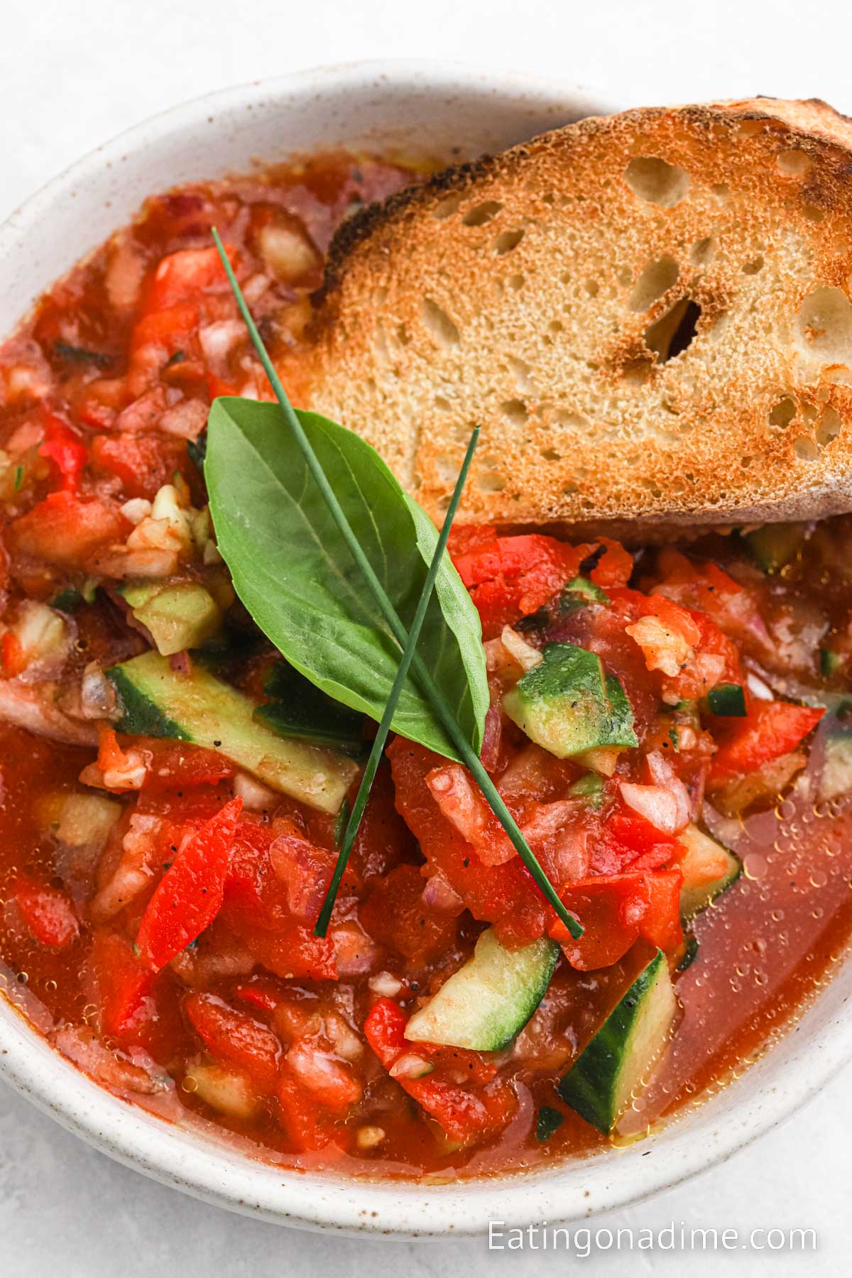 Close up image Ina Garten Gazpacho in a bowl with french bread 