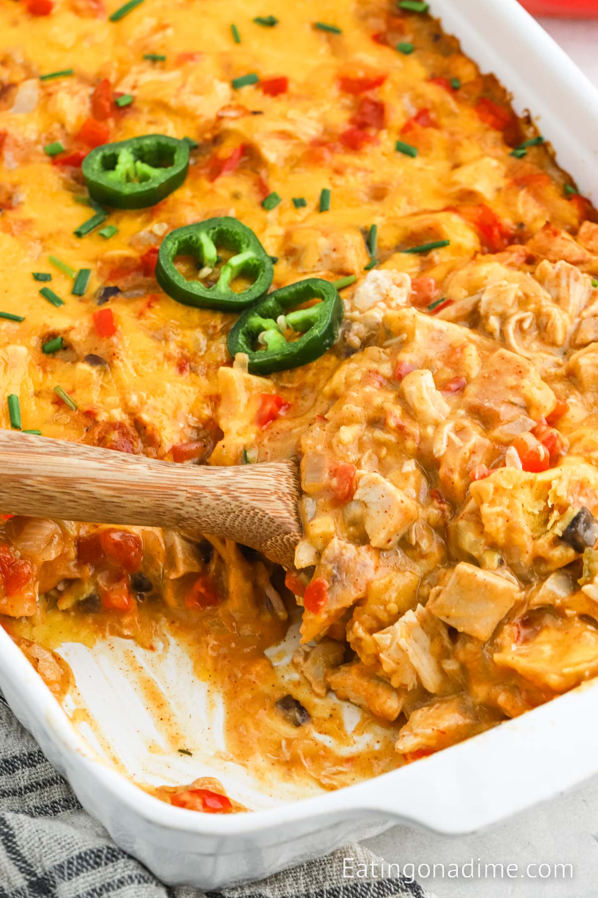 King Ranch Chicken Casserole in a baking dish with a wooden spoon