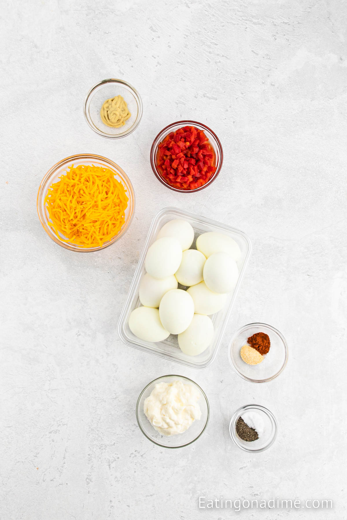 Hard boiled eggs, mayonnaise, cheddar cheese, mustard, pimento peppers, pepper, salt, garlic powder, paprika, chives
