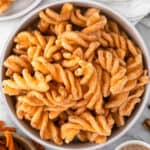 A bowl filled with crispy, twisted Taco Bell Cinnamon Twists coated in cinnamon sugar, viewed from above.