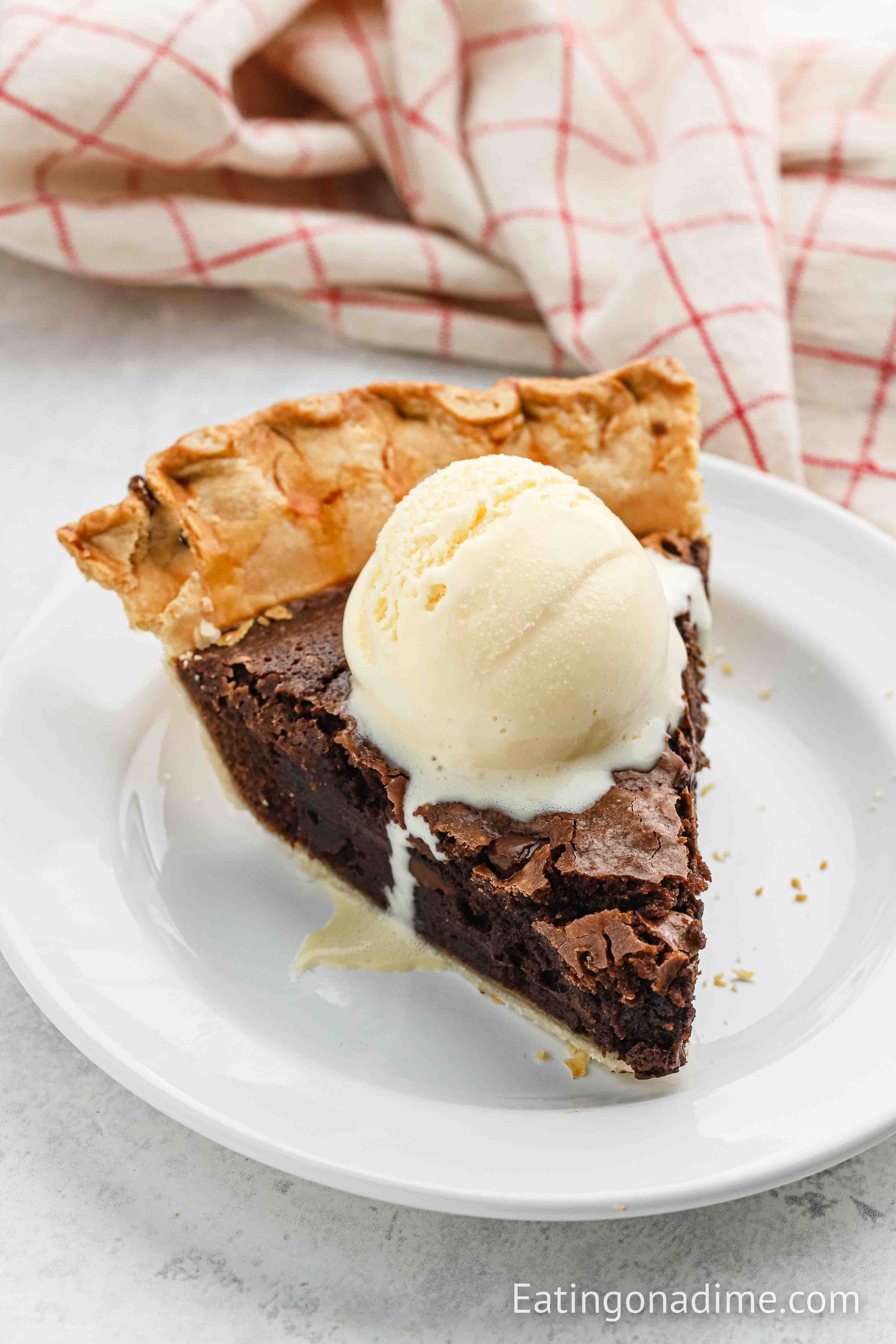 Close up image of Brownie Pie on a plate with a scoop of ice cream