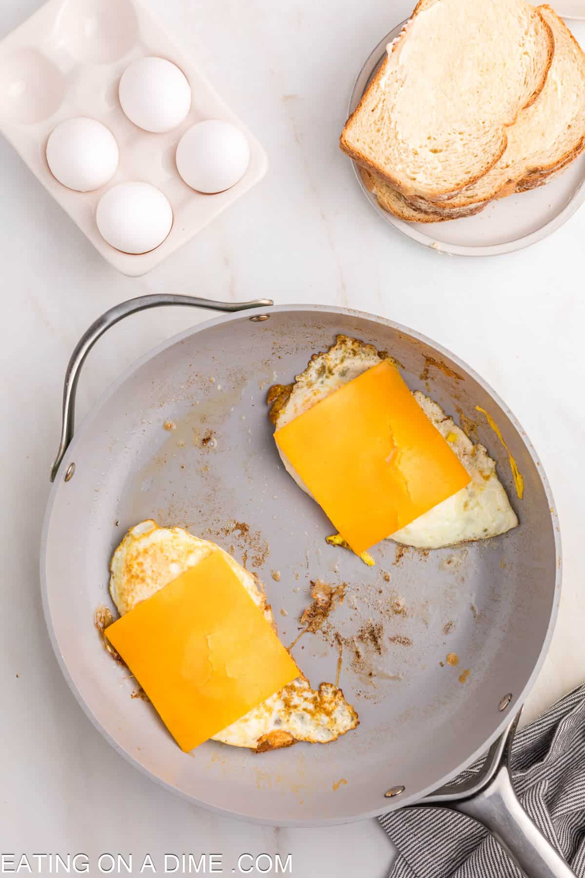 Topping fried eggs with slice cheese