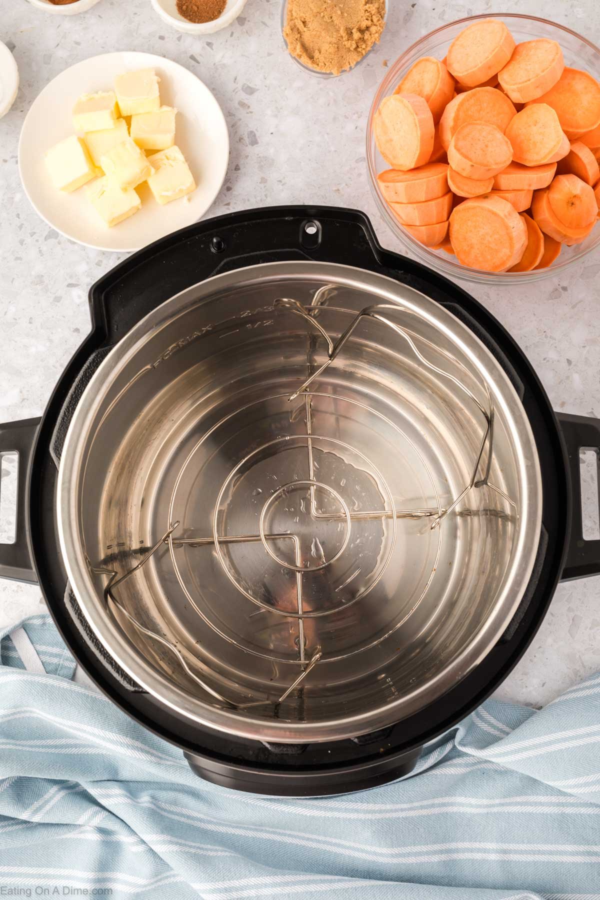 Instant Pot with water and small bowls of yams, spices and butter slices on a plate