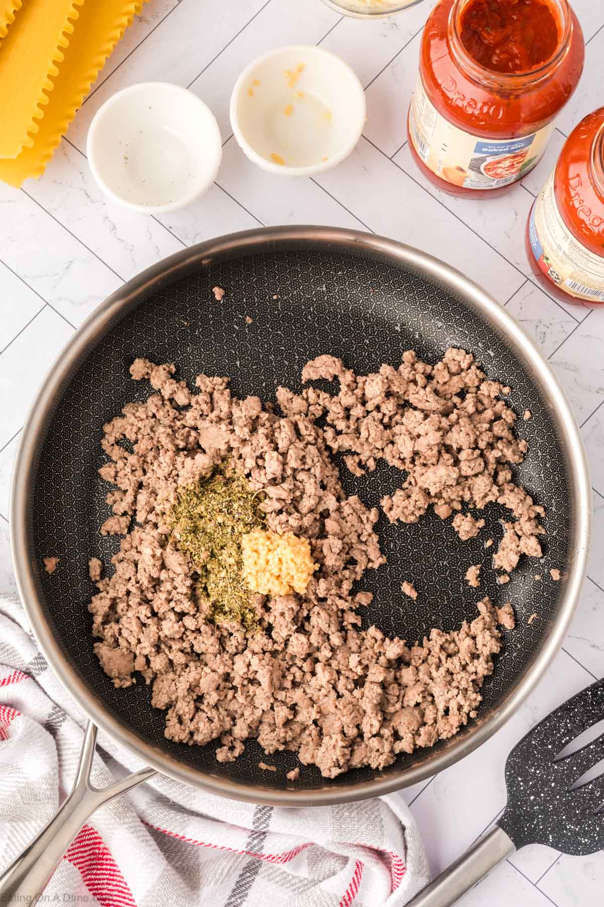 Adding the seasoning in the ground beef in the skillet
