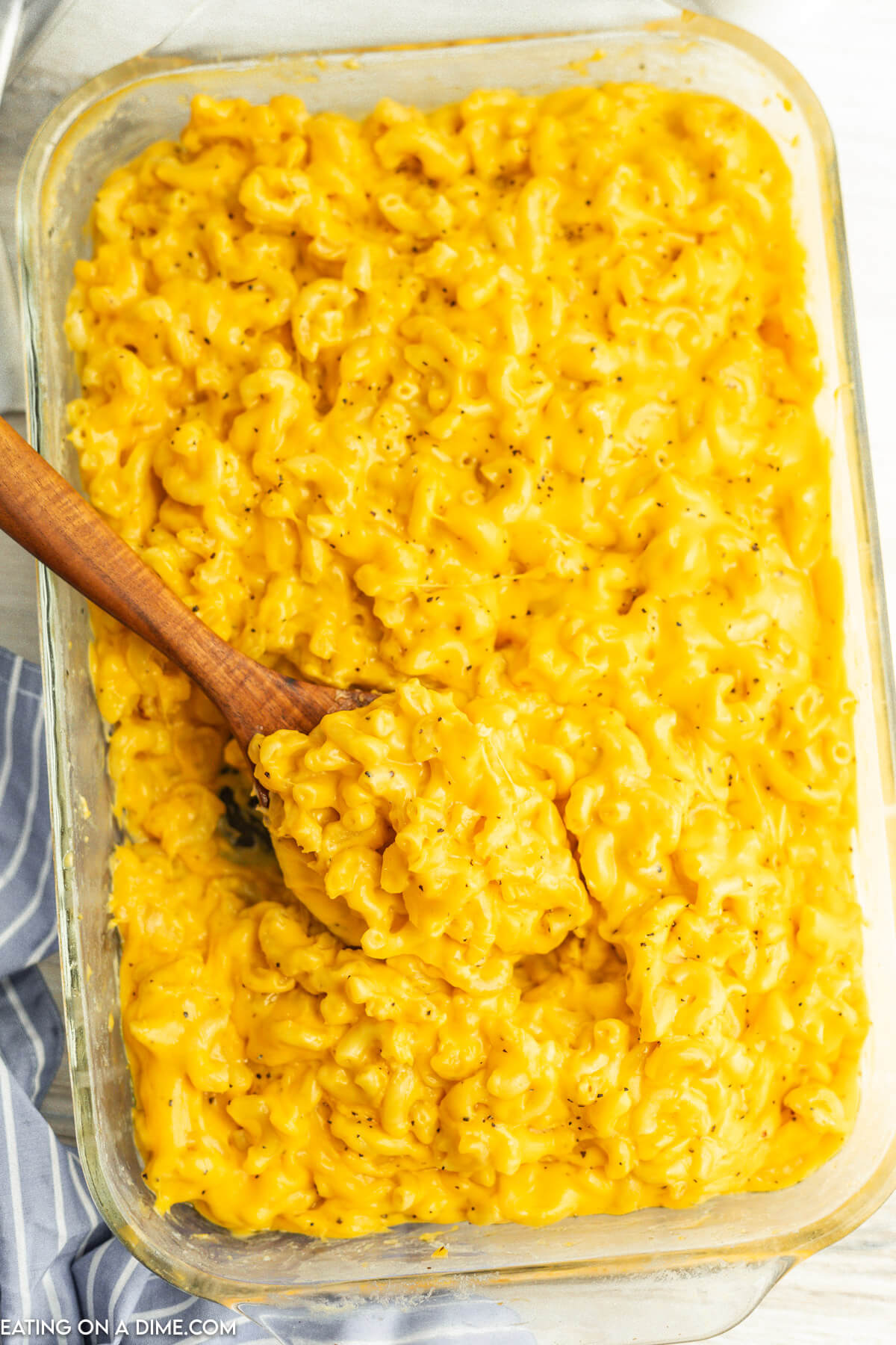 Mac and Cheese in a baking dish with a wooden spoon