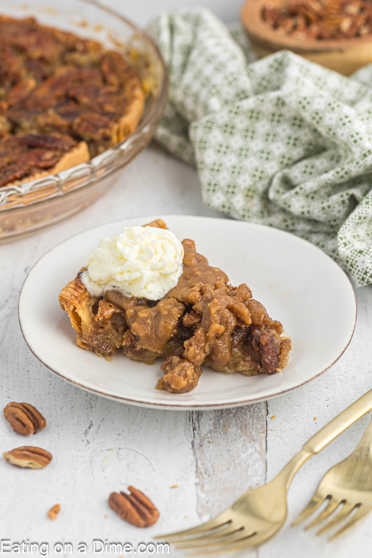 Slice of pecan pie on a plate with whipped cream