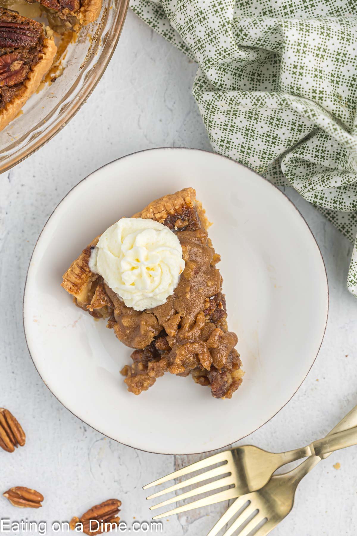 Slice of pecan pie on a plate with whipped cream