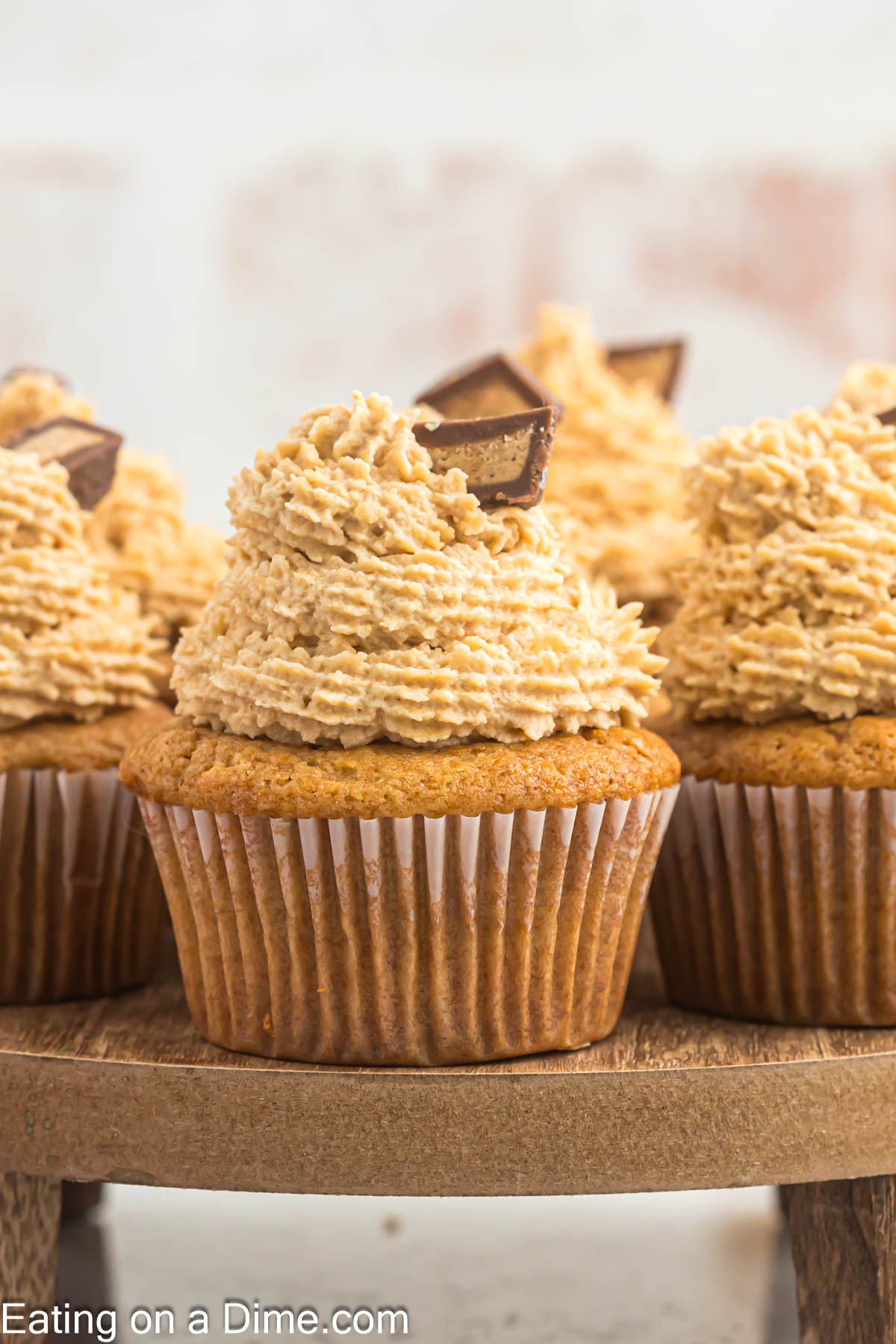 Close up image of peanut butter cupcakes topped with mini Reese's Cups