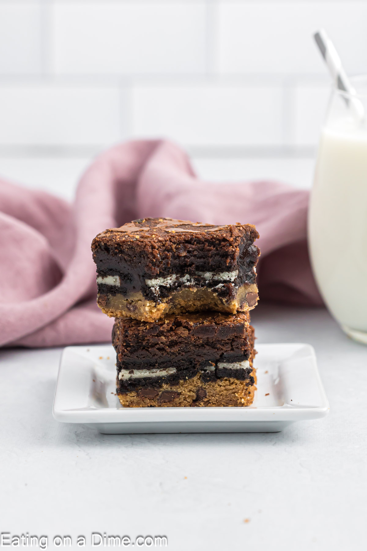 Slutty Brownies cut into squares and stacked on a white plate