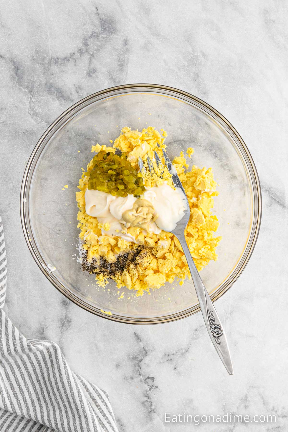 Egg yolk mashed in a bowl with relish, mayo and mustard with seasoning