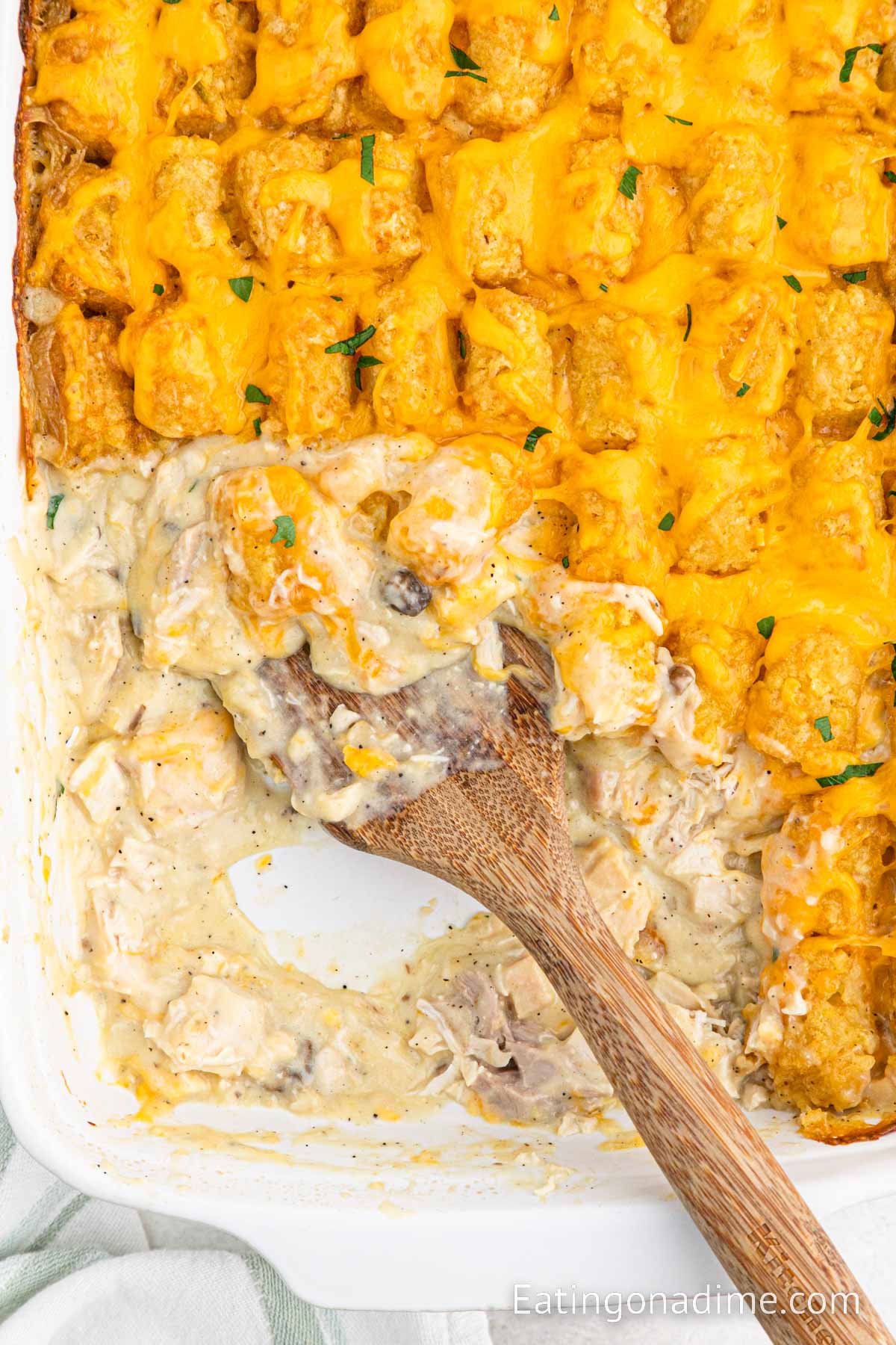 Chicken Tater Tot Casserole in a baking dish with a wooden spoon