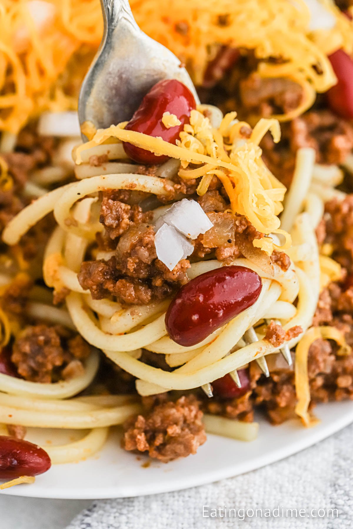 Cincinnati Chili on a plate with a serving on a fork