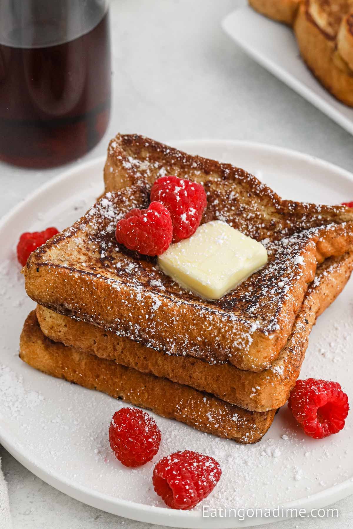 Cinnamon French Toast Stacked on a plate with butter and fresh berries