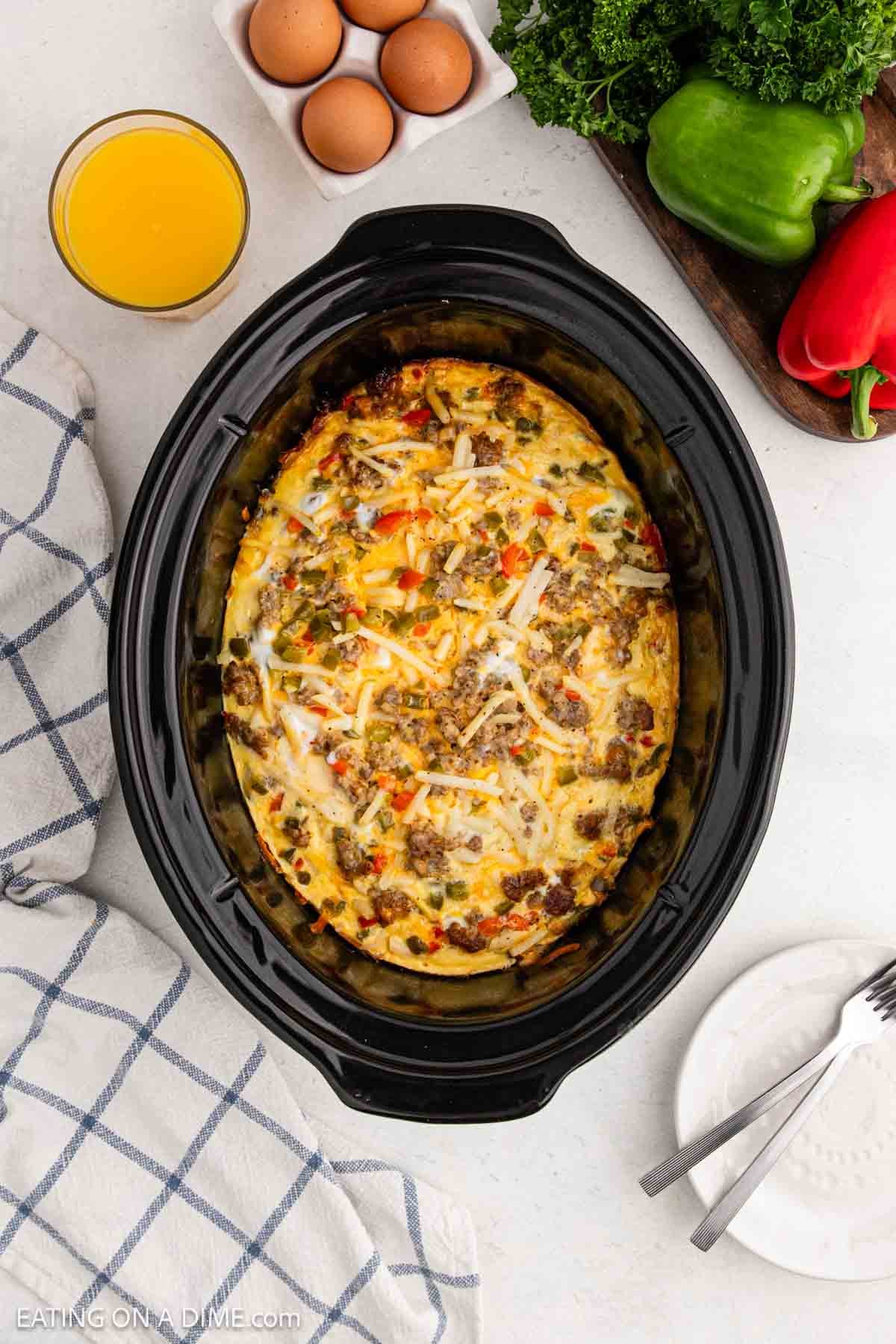 Cooked egg in the crockpot mixed with sausage, cheese and veggies.