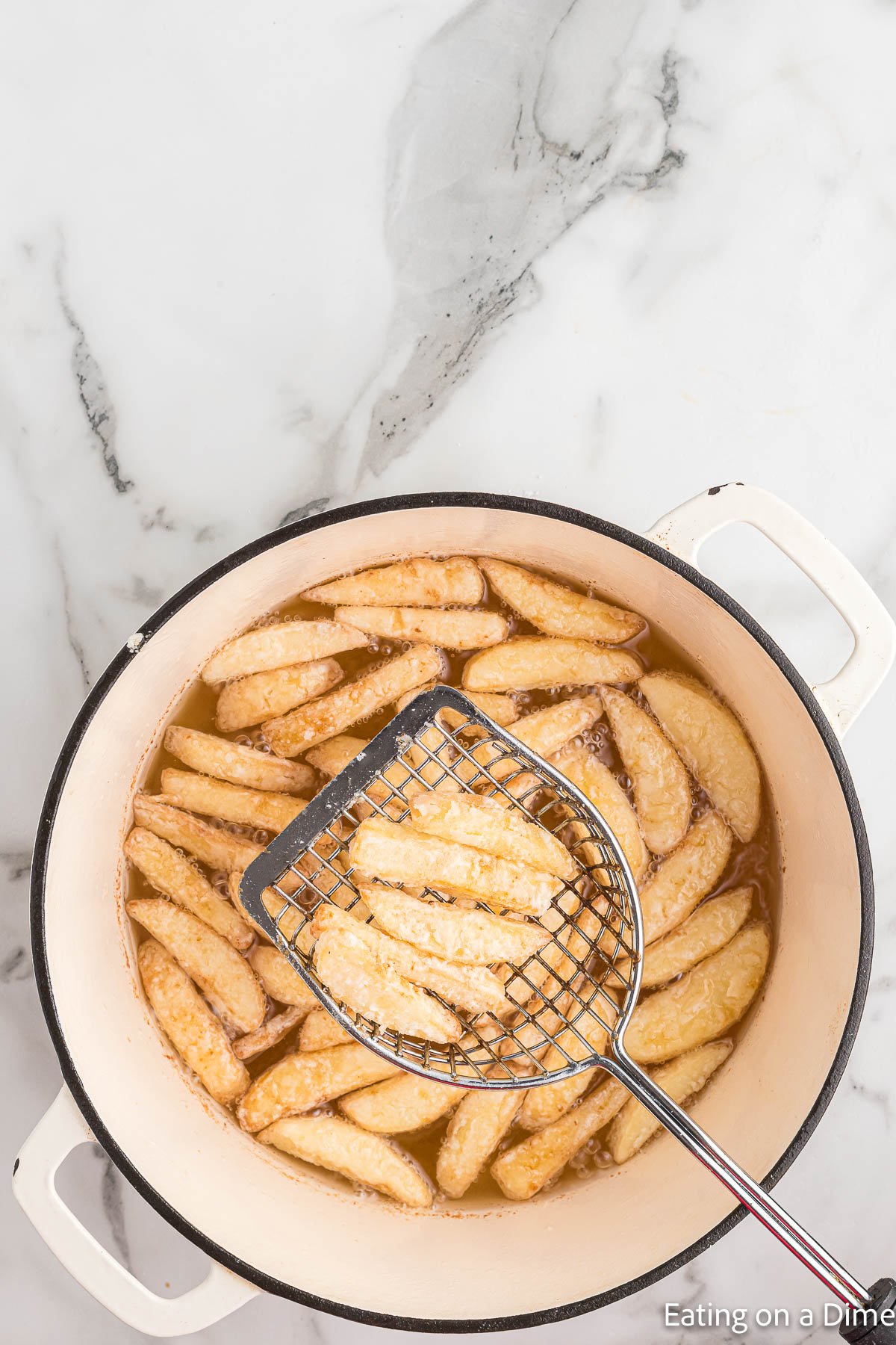 Frying the apple slices in a large pot