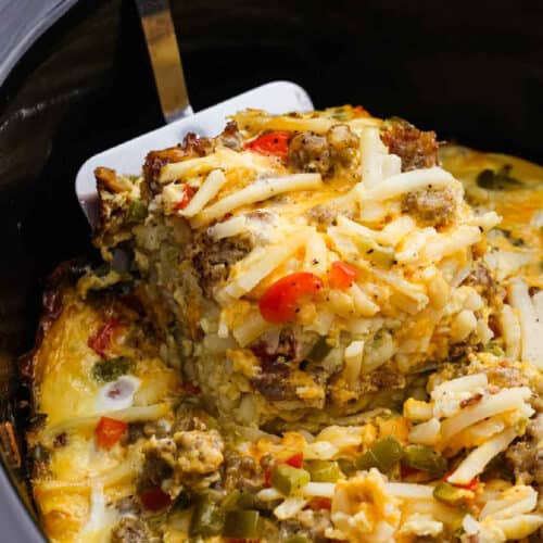Breakfast Casserole in the crockpot with a serving on a spatula.