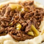 Mississippi Pot Roast-style shredded beef with pepperoncini peppers served on a bed of creamy mashed potatoes.