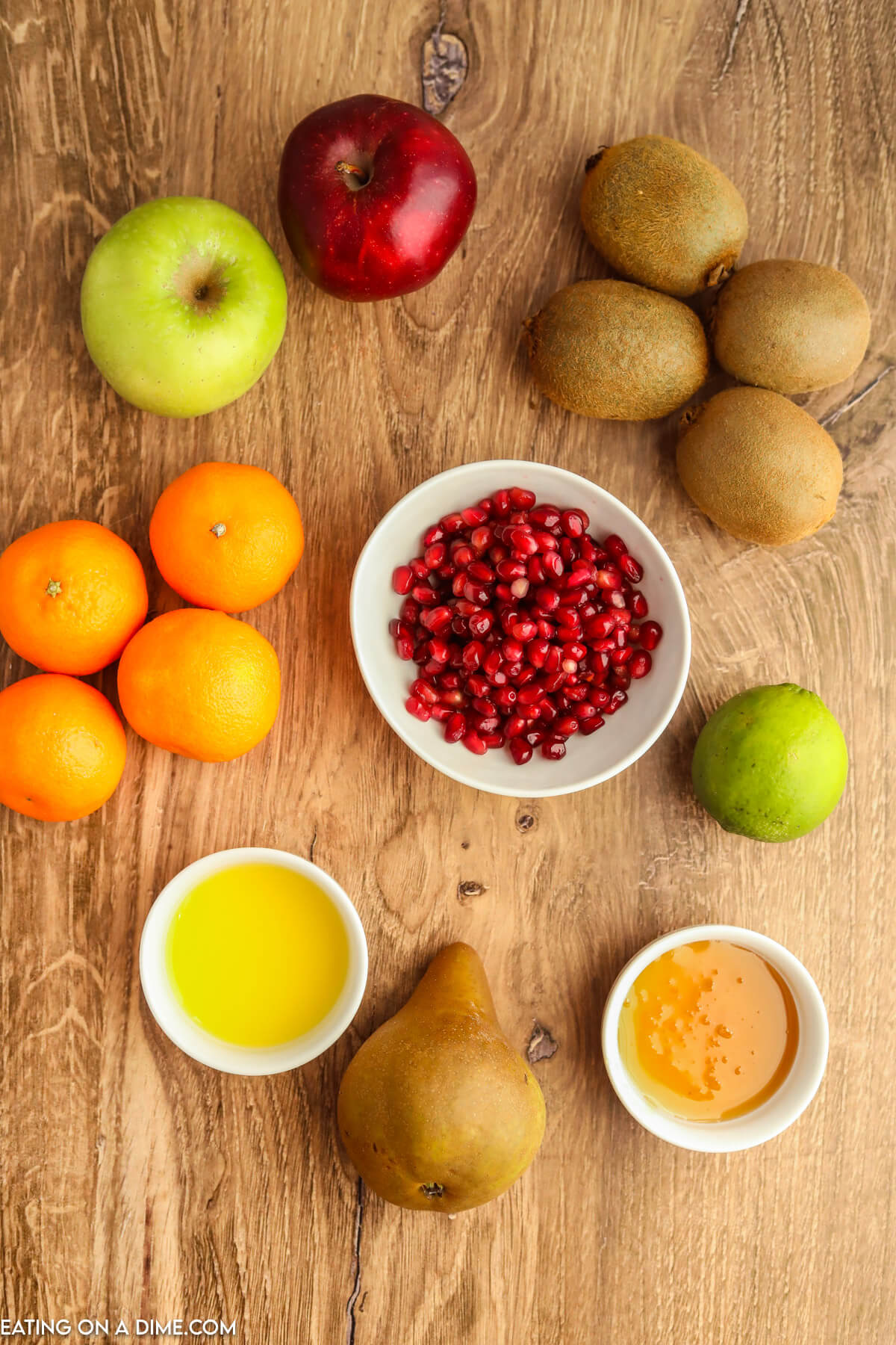 Ingredients for Winter Fruit Salad- pomegranates, oranges, kiwi, apples, pears, honey, lime juice. 