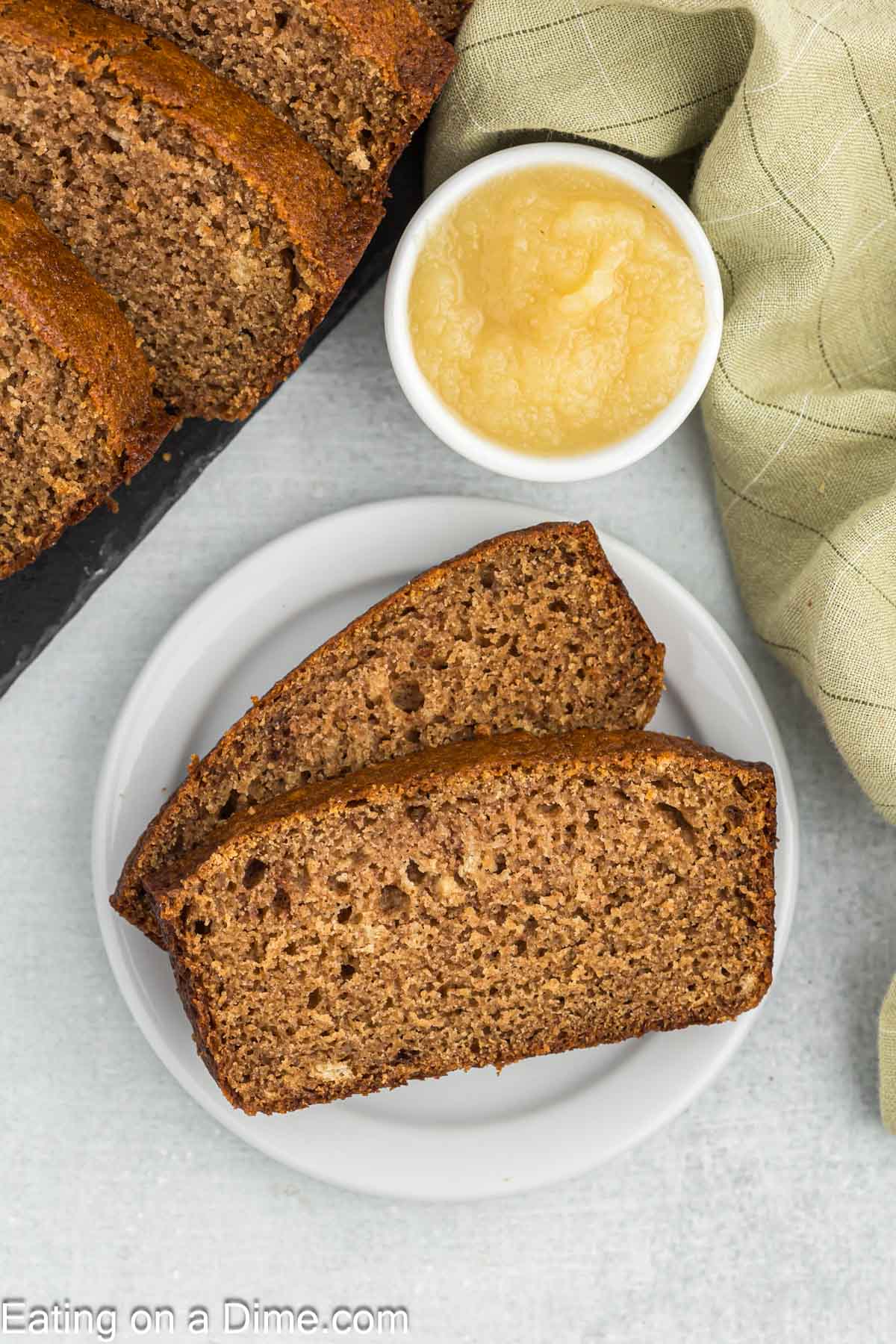 applesauce bread slices on a plate next to a bowl of applecauce