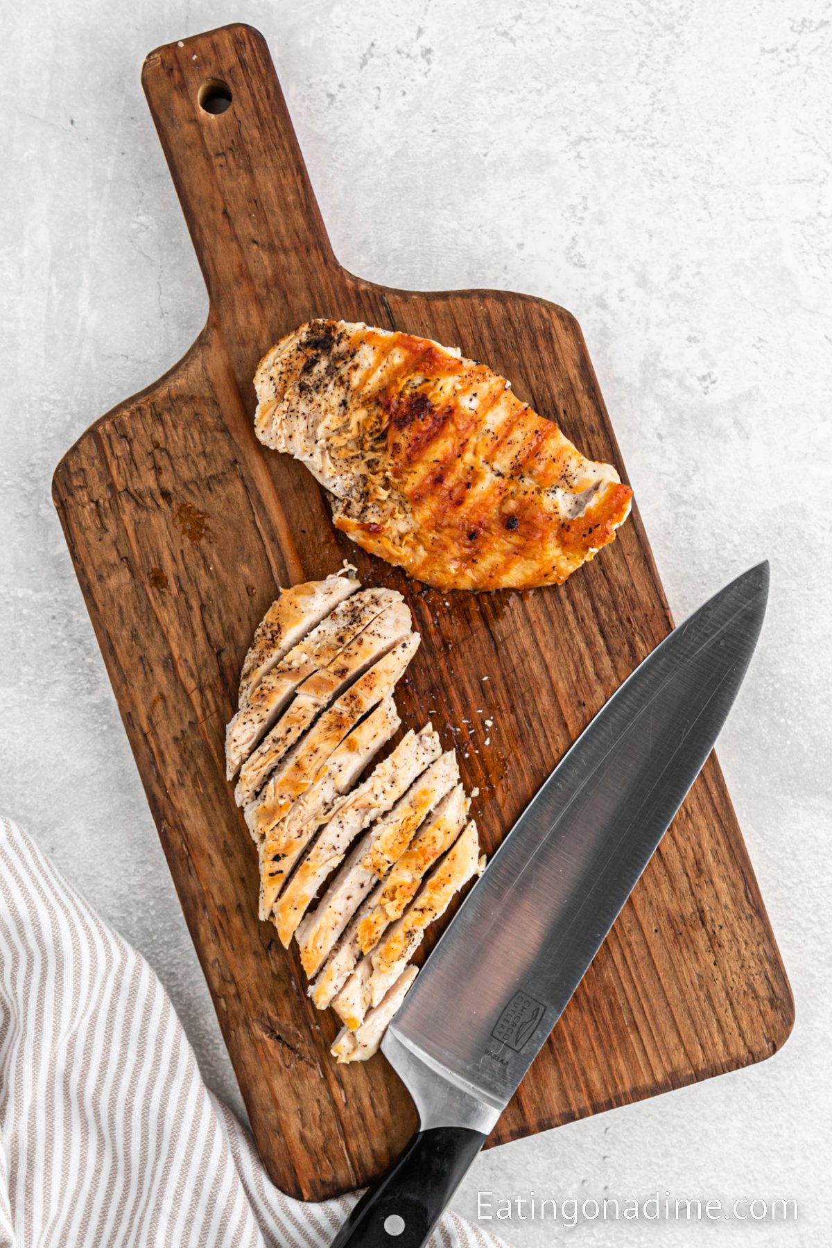Slicing cooked chicken on a cutting board