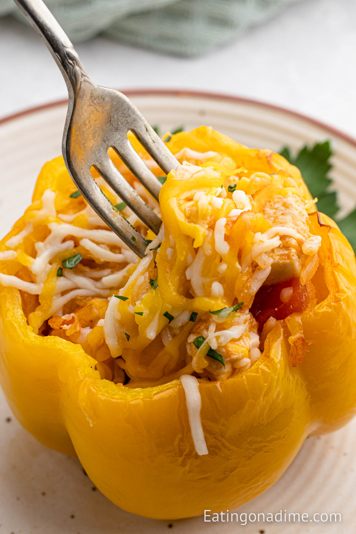 Close up image of chicken stuffed peppers on a plate with a fork