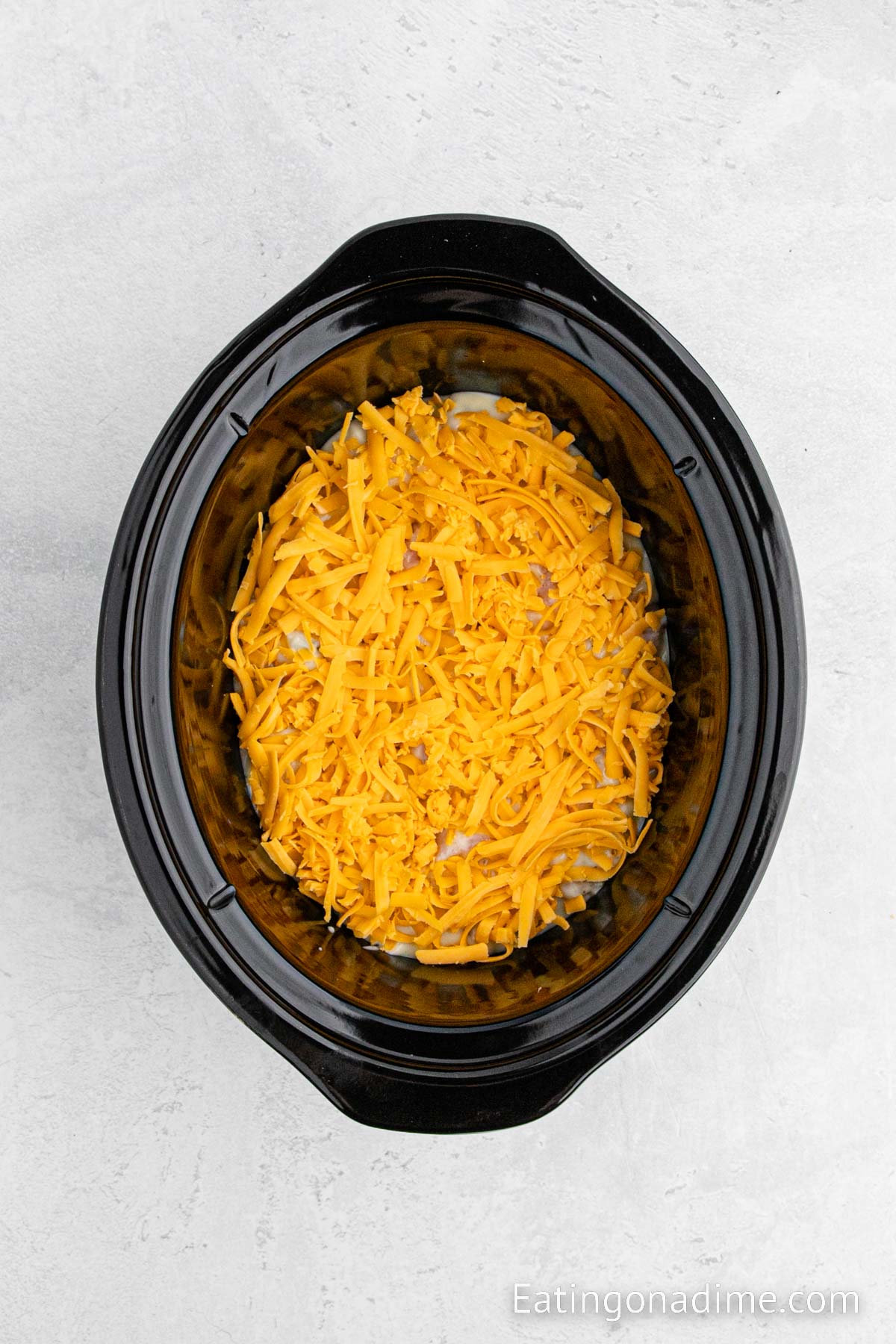 Adding in a layer of shredded cheese in the slow cooker
