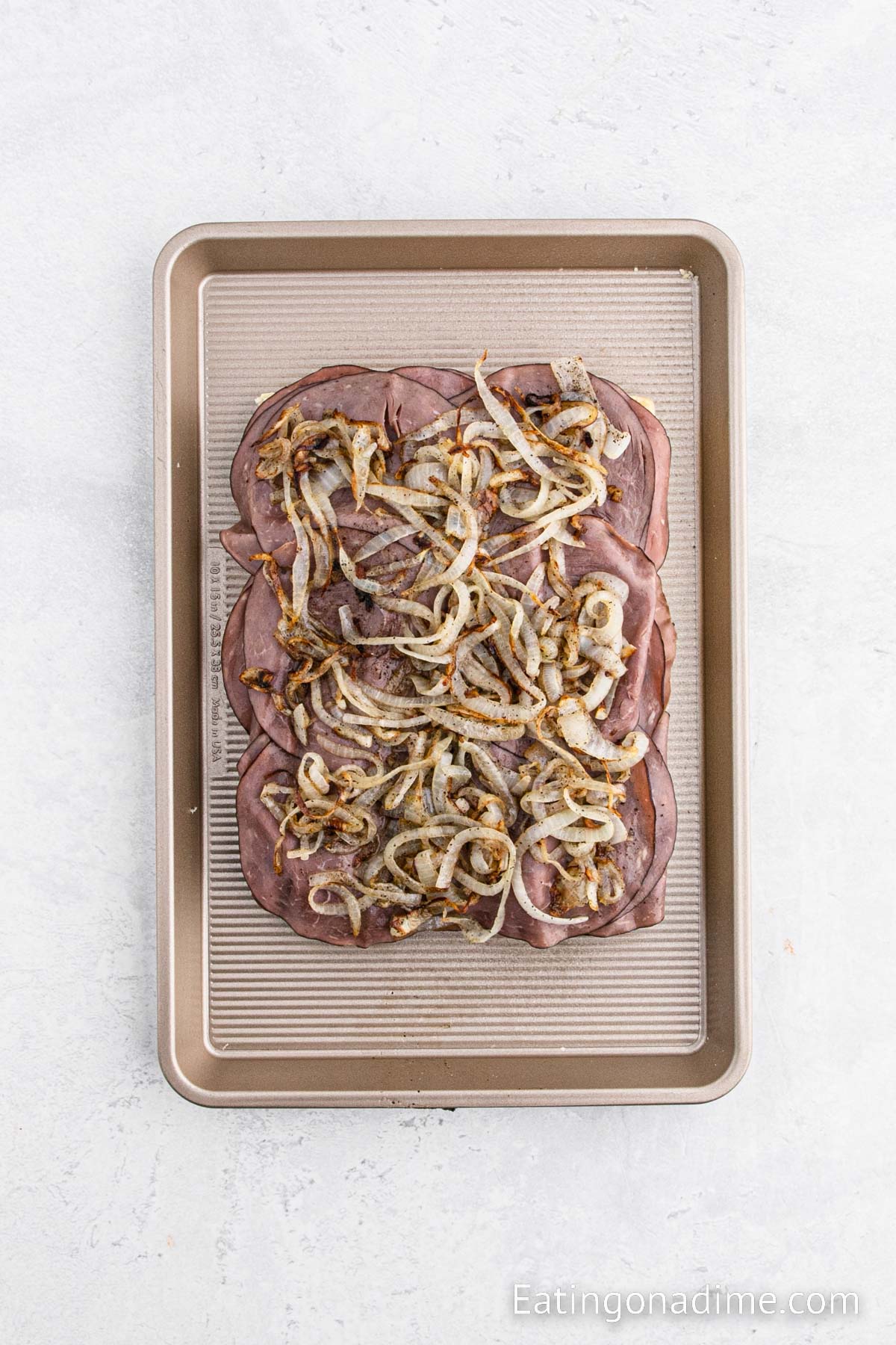 Topping the roast beef with the cooked onions