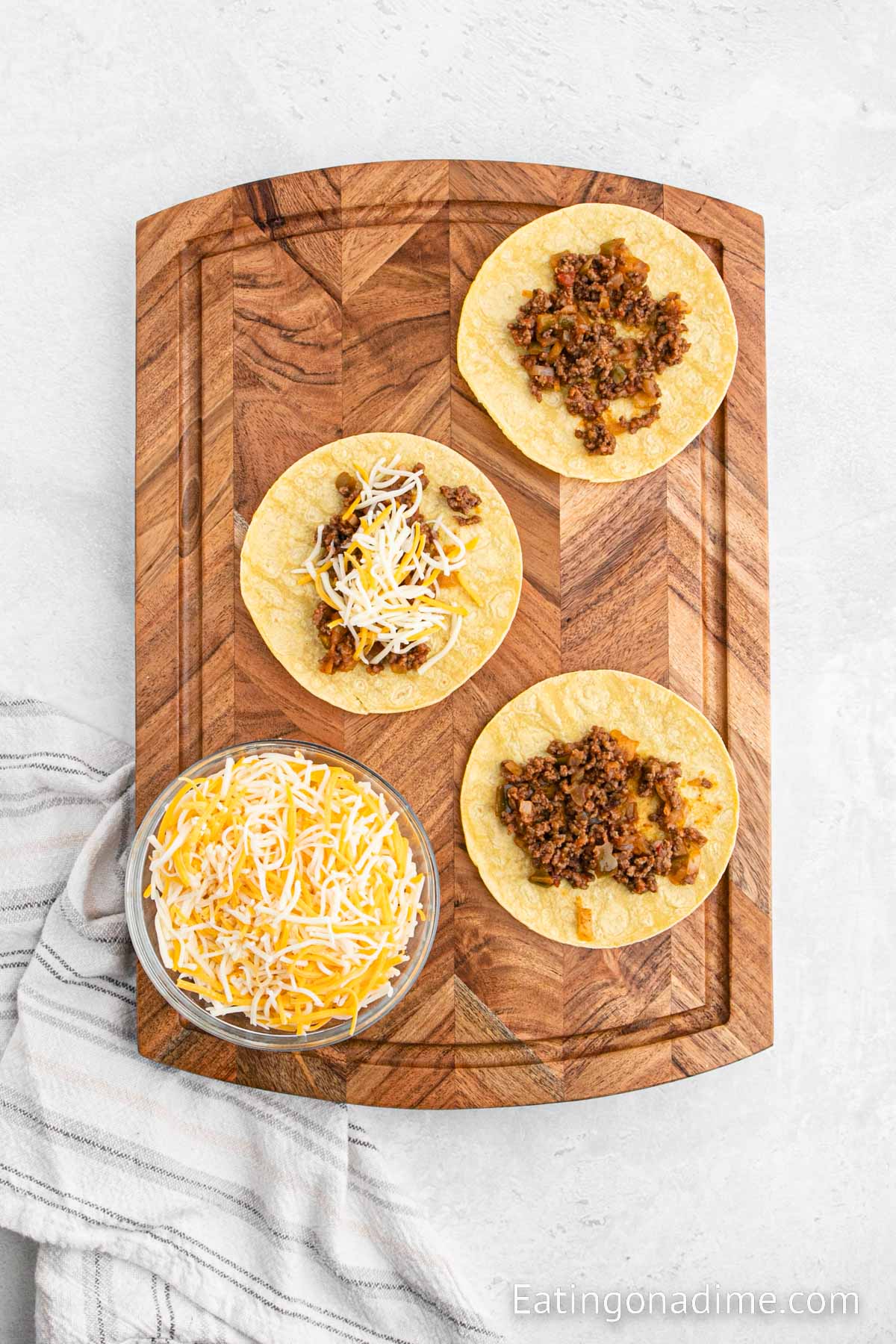 Layering the taco shells with the beef mixture and cheese 