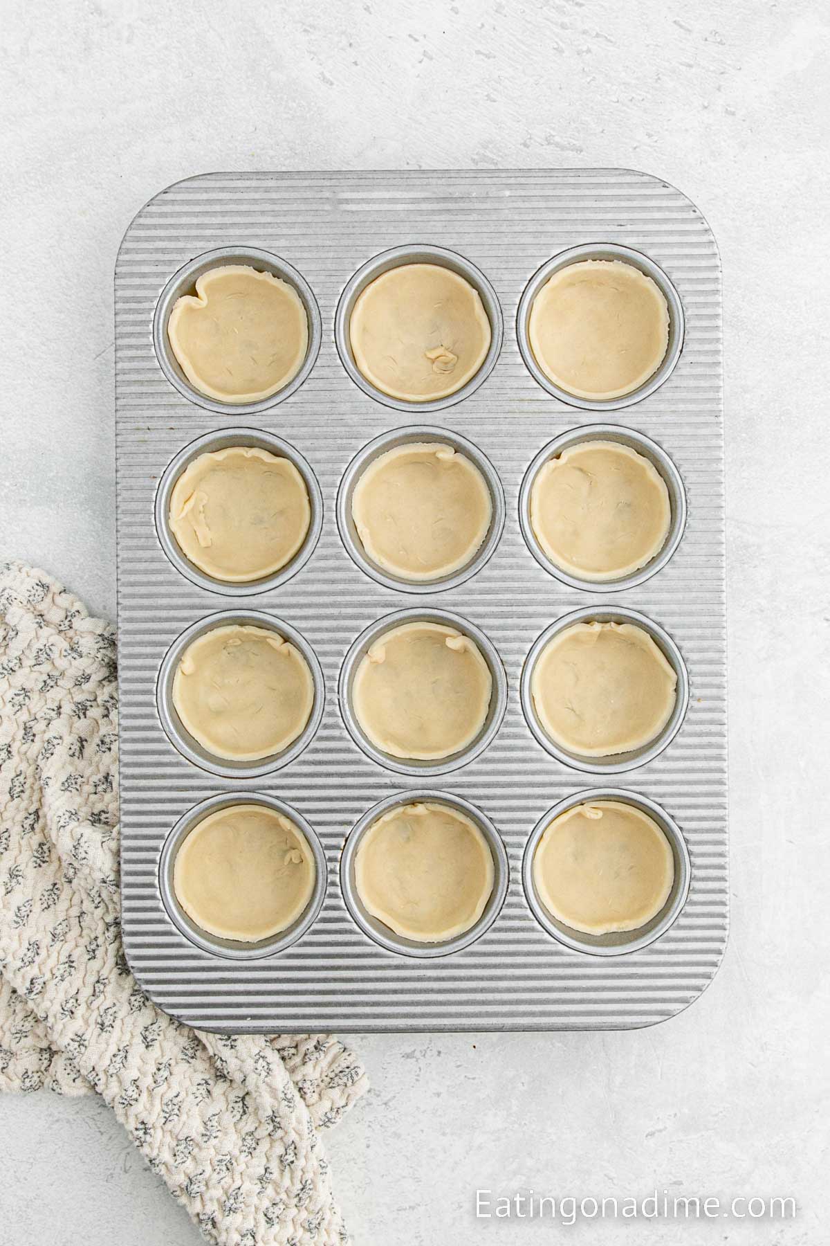 Pressing the dough into the muffin tin