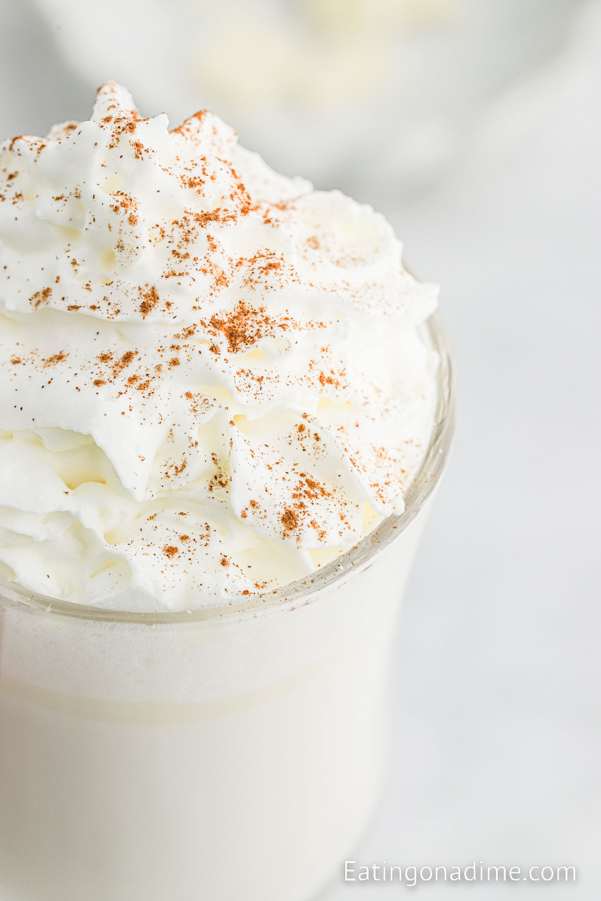 White Hot Chocolate in clear mugs topped with whipped cream topped with cinnamon