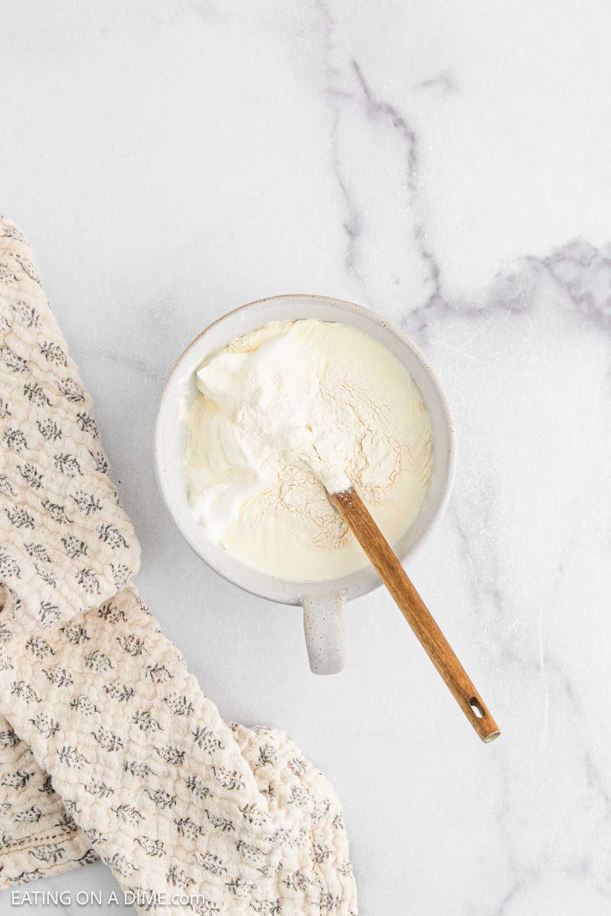 Combining the xantham gum, heavy cream, sour cream in a bowl