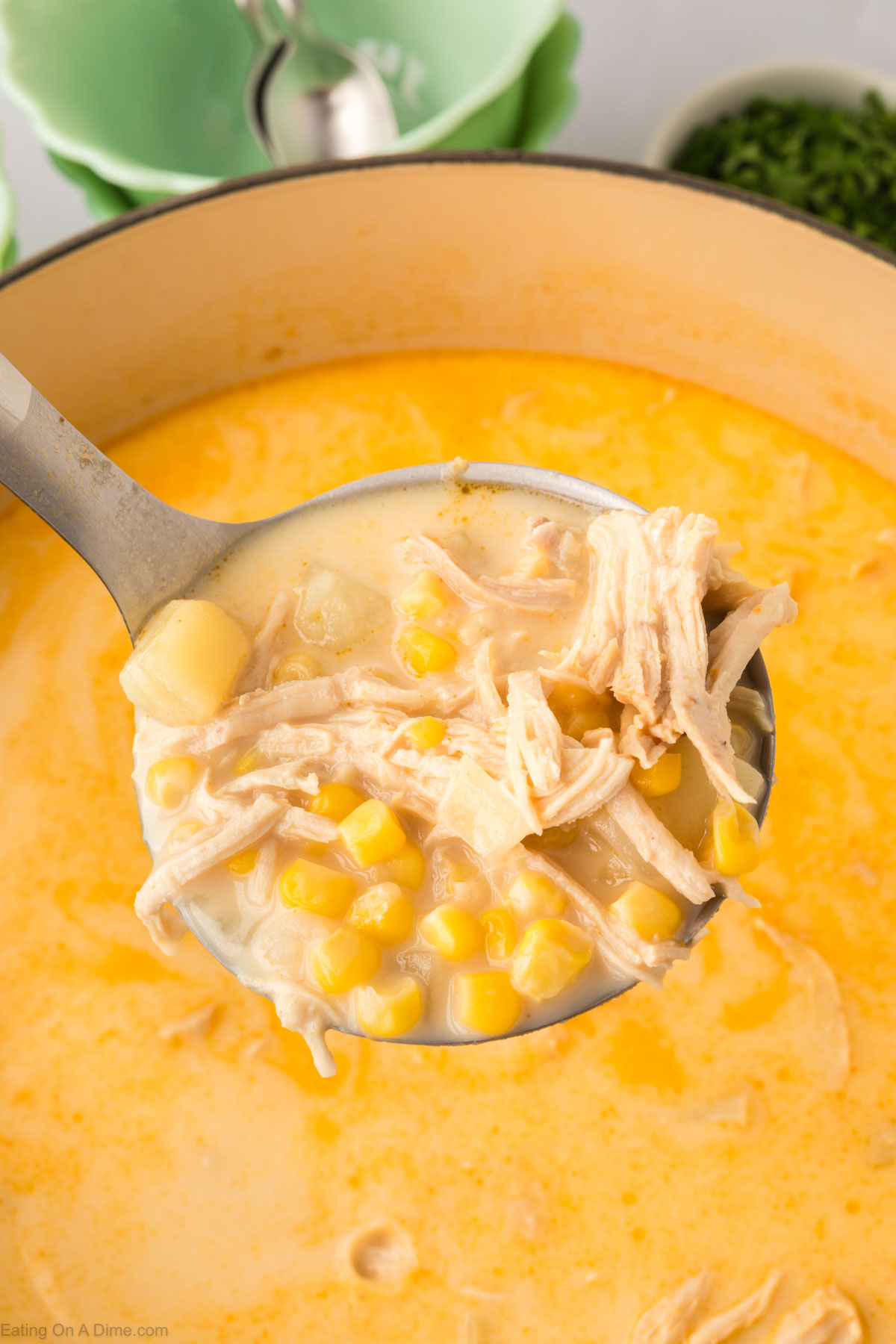 Close up image of chicken corn soup in a ladle
