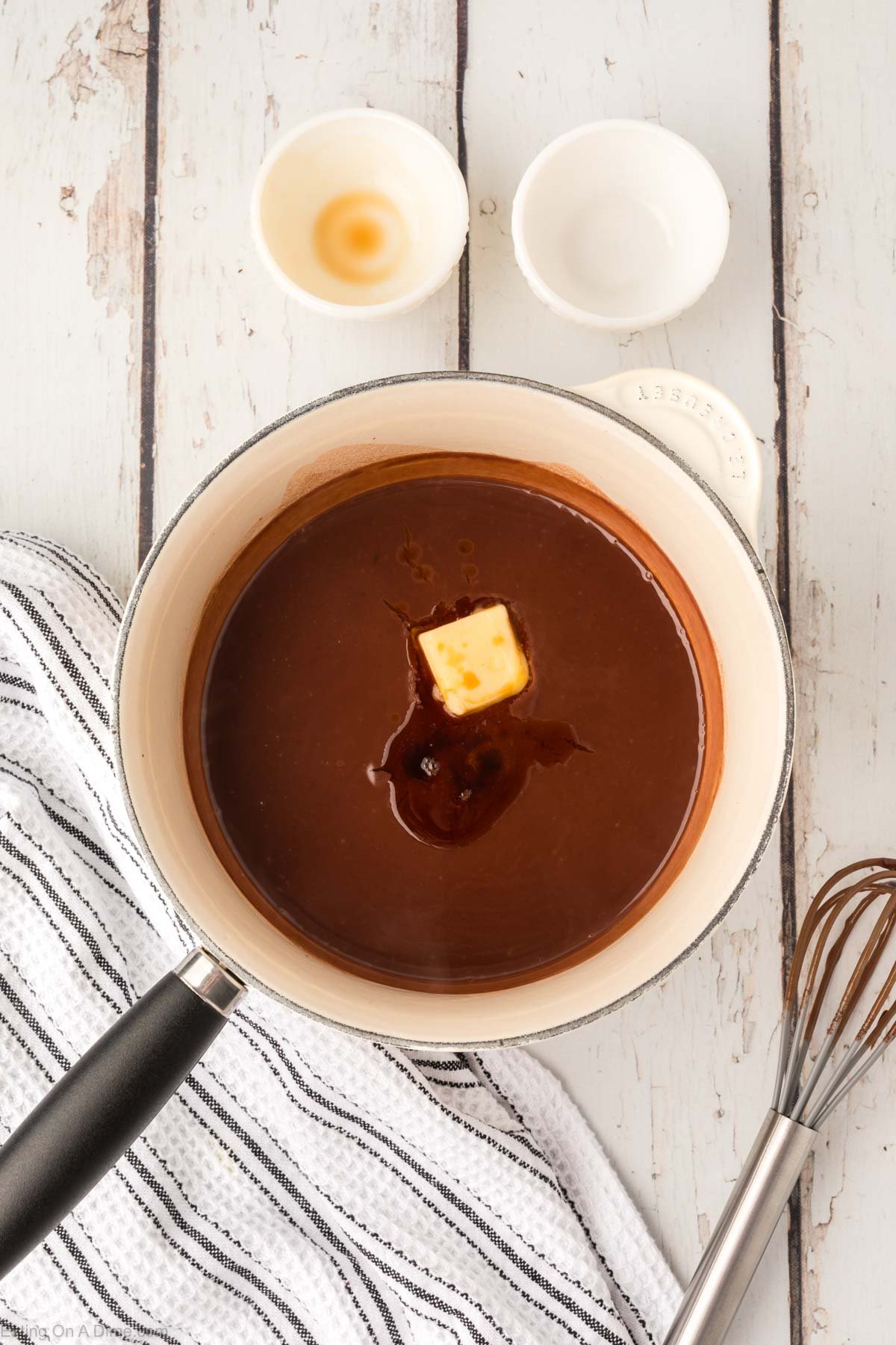 Adding the vanilla extra and butter to the chocolate gravy mixture in a sauce pan