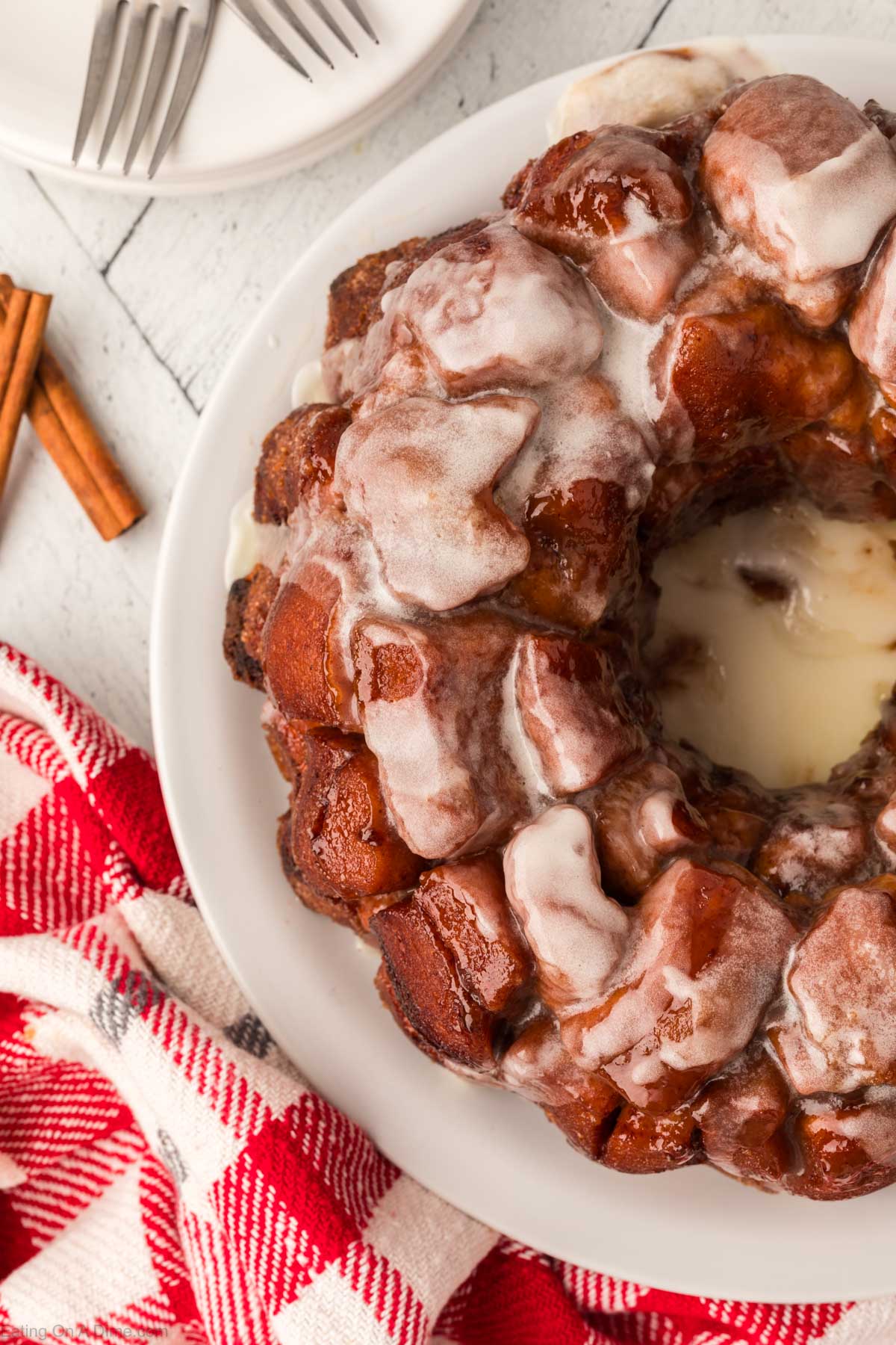 Cinnamon Roll Monkey Bread on a white plate topped with the glaze