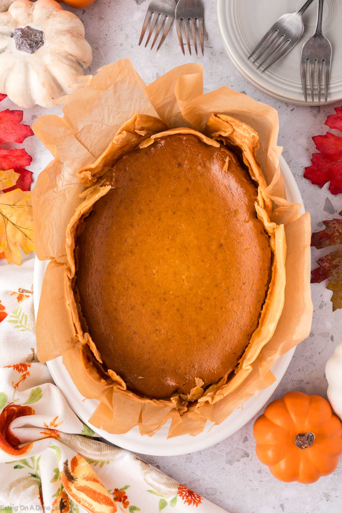 Pumpkin Pie cooked in the slow cooker on a platter with parchment paper