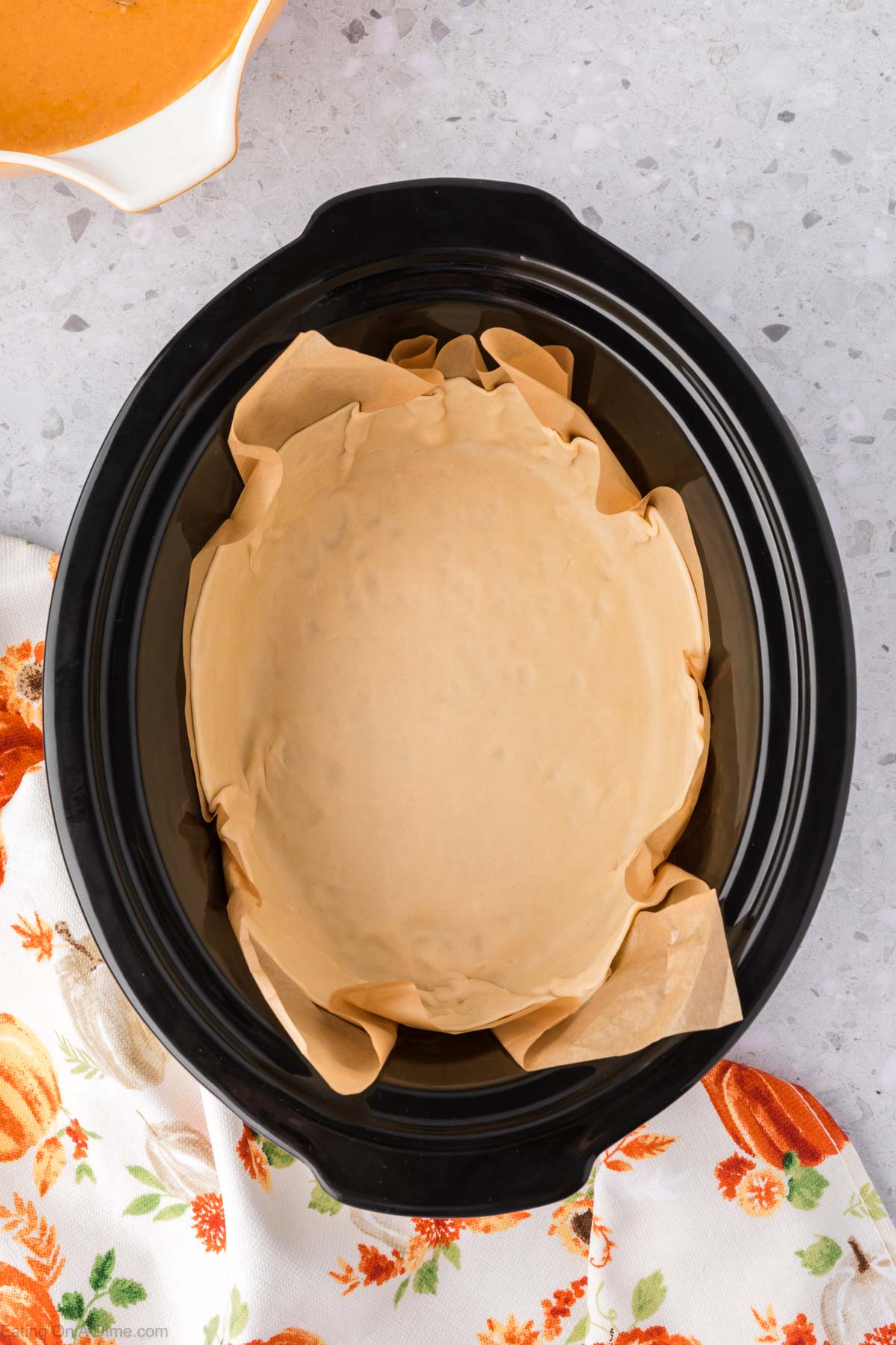 Placing the pie crust dough in the slow cooker 