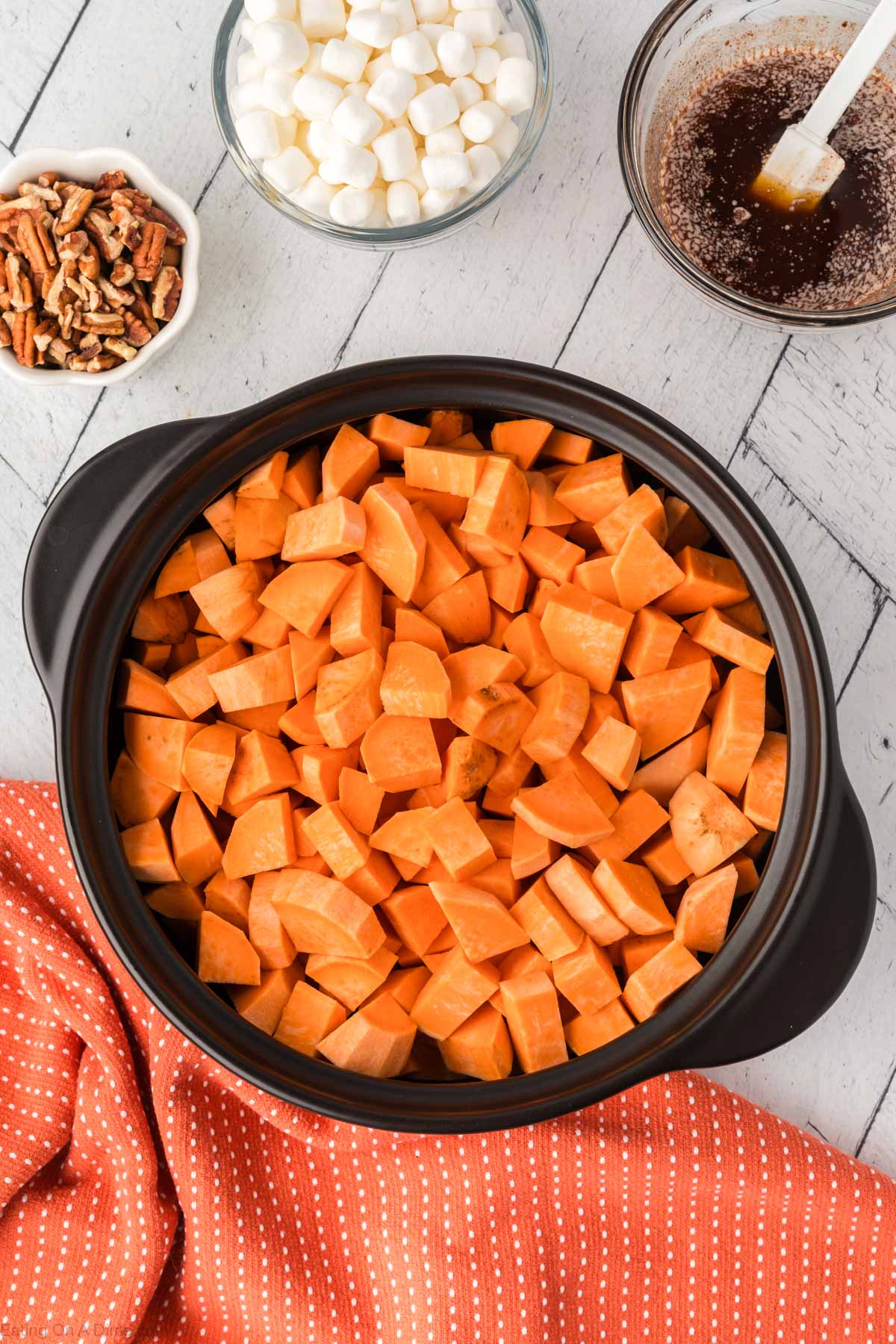 The diced sweet potatoes placed in a slow cooker.  