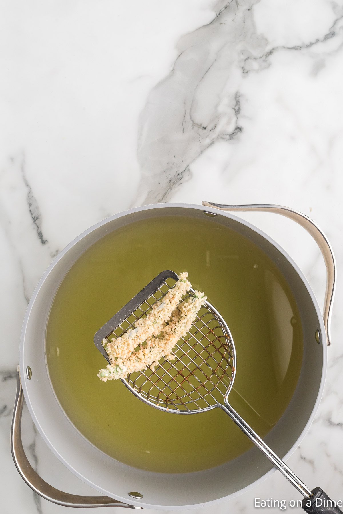 Frying the green beans in a large pot of hot oil