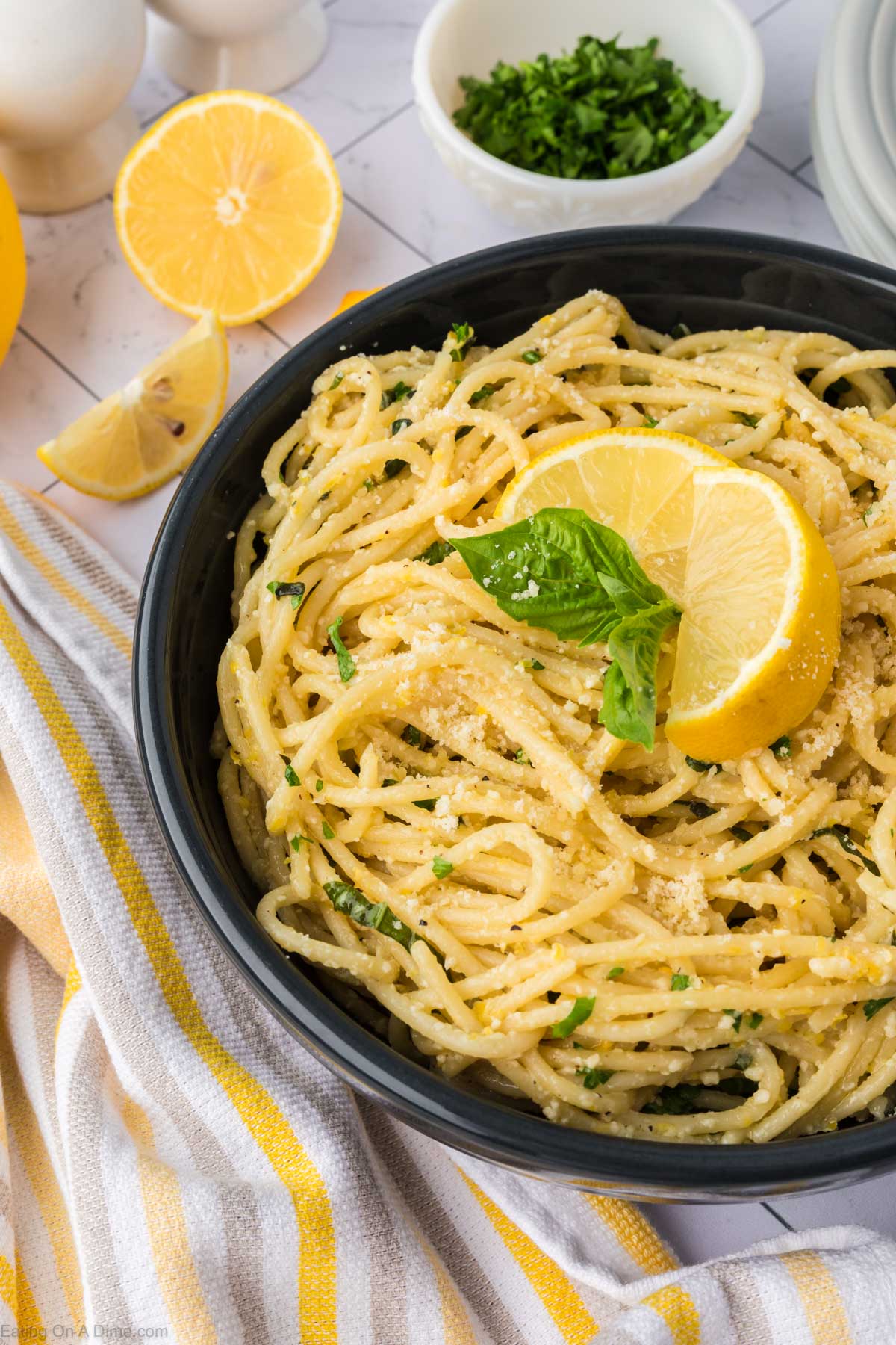 Lemon Spaghetti in a bowl topped with fresh lemon wedges