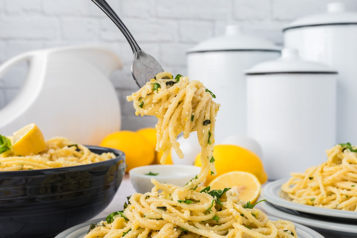 Lemon spaghetti on a plate with a serving on the fork